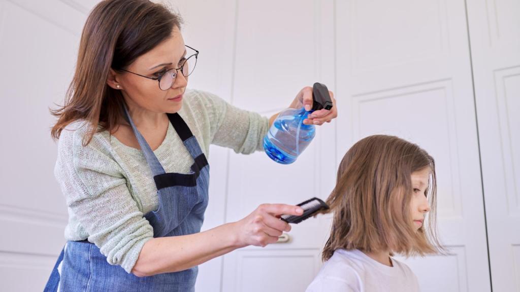 woman cutting girl's hair