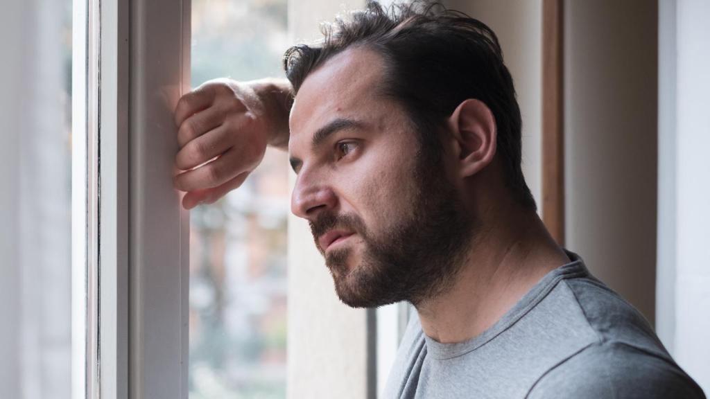 man looking out a window