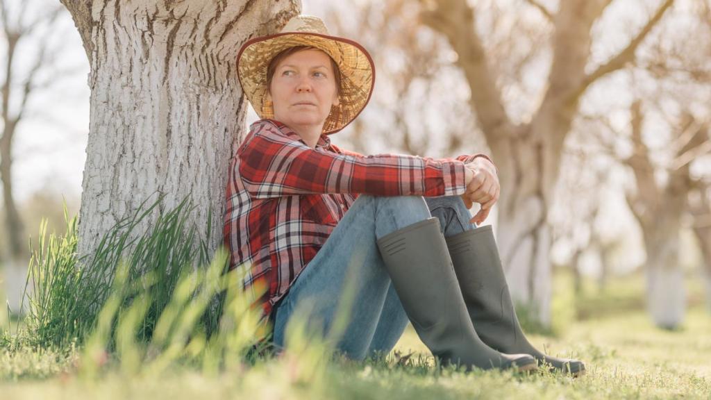 woman sitting against a tree