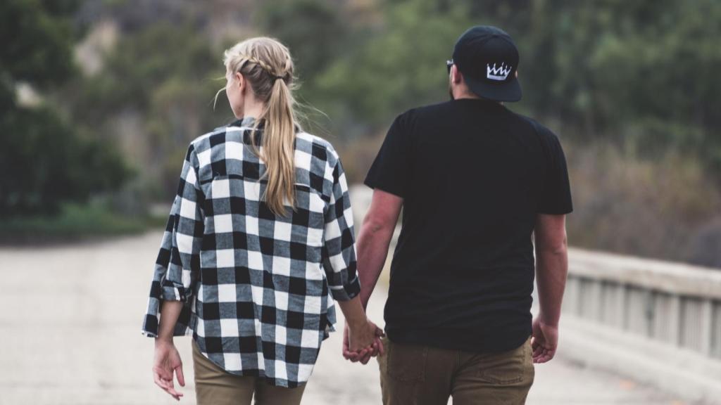 couple holding hands walking down the street