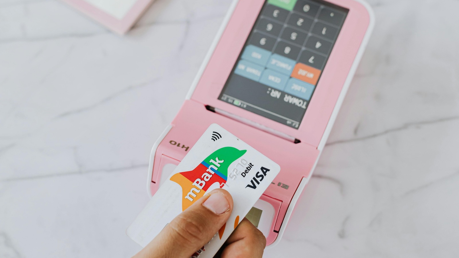 person paying on a pink atm with a credit card