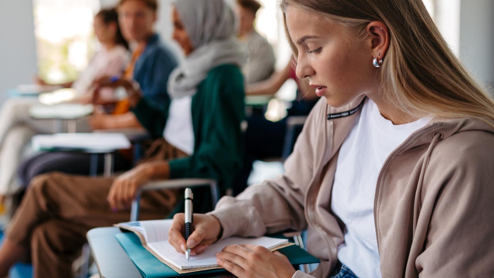 woman taking notes in class