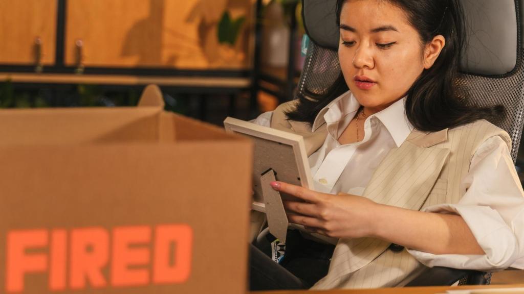 fired woman packing up her desk
