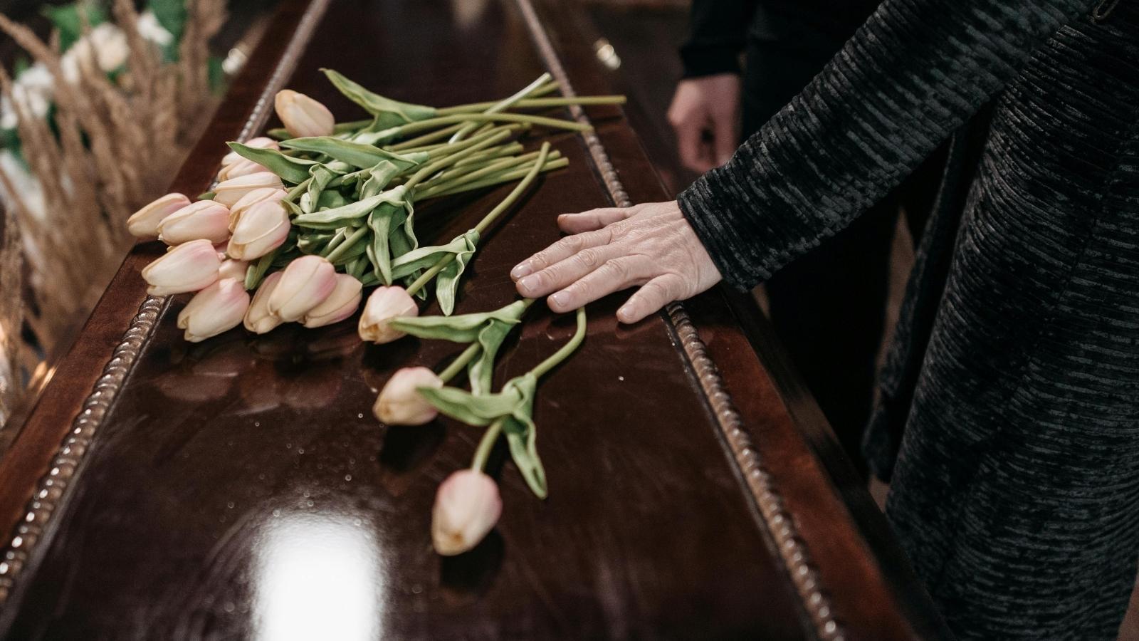 Woman Wants Flowers at Mother’s Funeral, but Family Says Money Should Go to Care Home Instead flowers sitting on a casket