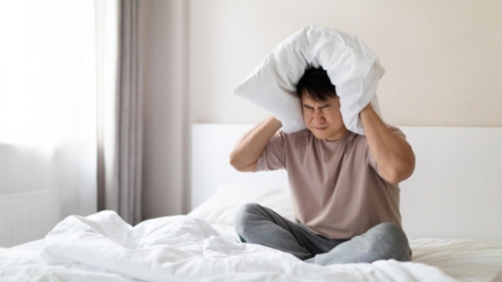 After 14 Years of Noisy Upstairs Neighbors, They Thought the Nightmare Was Over. They Were Wrong. Covering ears with pillow