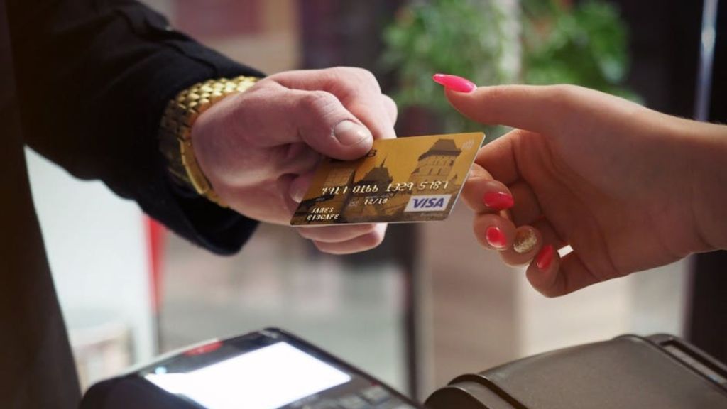 man handing his credit card to an employee