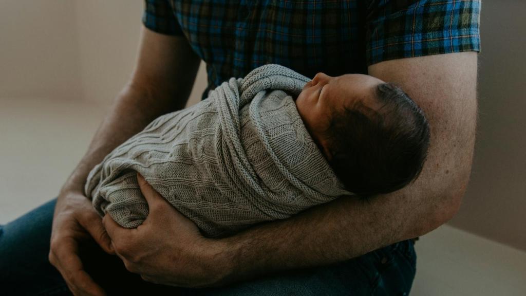 man holding a new baby