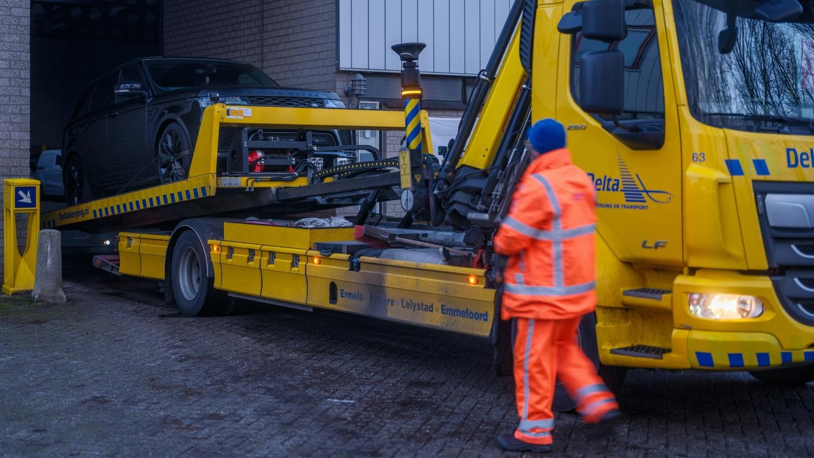 A Blocked Driveway Warning Leads to an Unexpected Overnight Showdown man in orange suit operating a big yellow tow truck