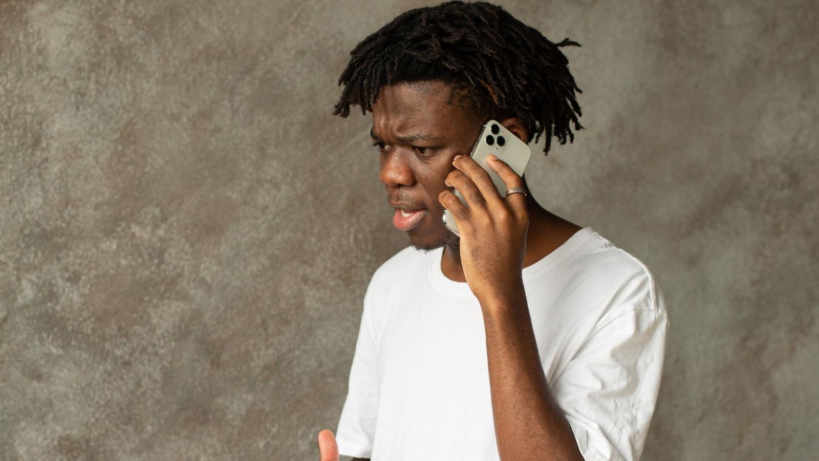 man in white shirt talking on phone