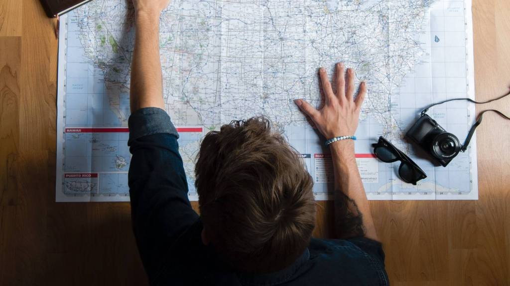 man planning a vacation on a map