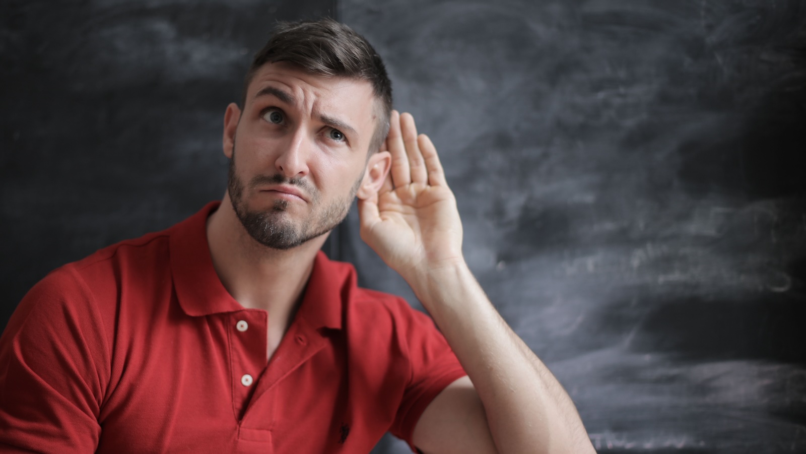 Coworker Refuses to Acknowledge Hearing Loss, Leaving Colleague Frustrated Over Workplace Accommodations man who can't ear putting hand to ear