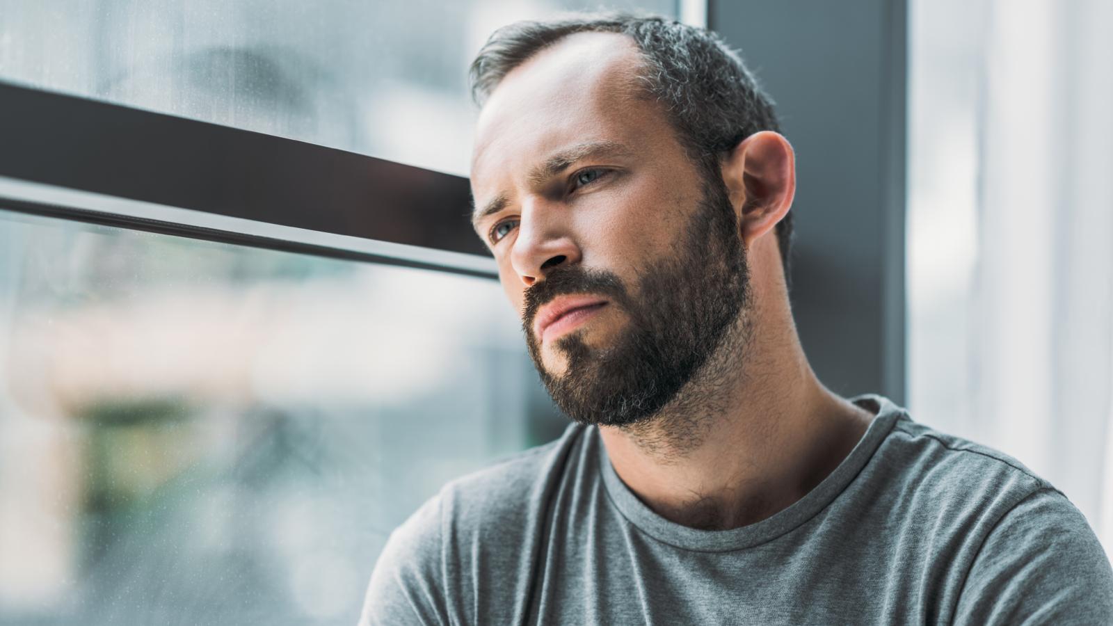 New Neighbors Are Using Bug Spray and Bug Bombs as Revenge for Minor Noise — and Its as Strange as It Sounds man looking out a window
