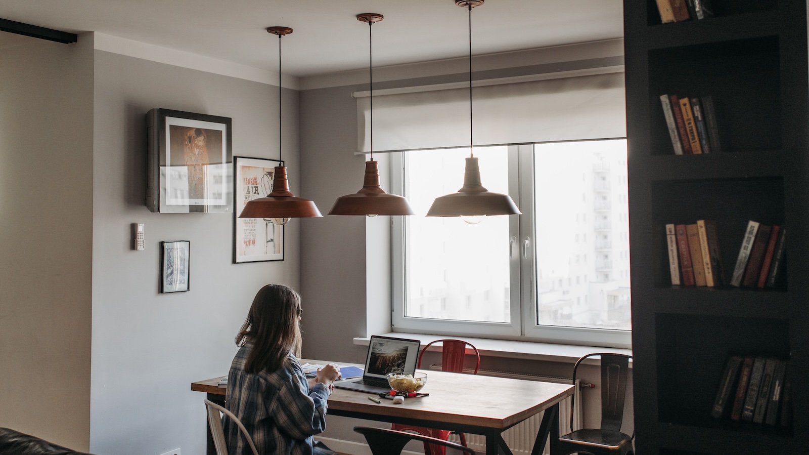 woman sitting in apartment at island from behind