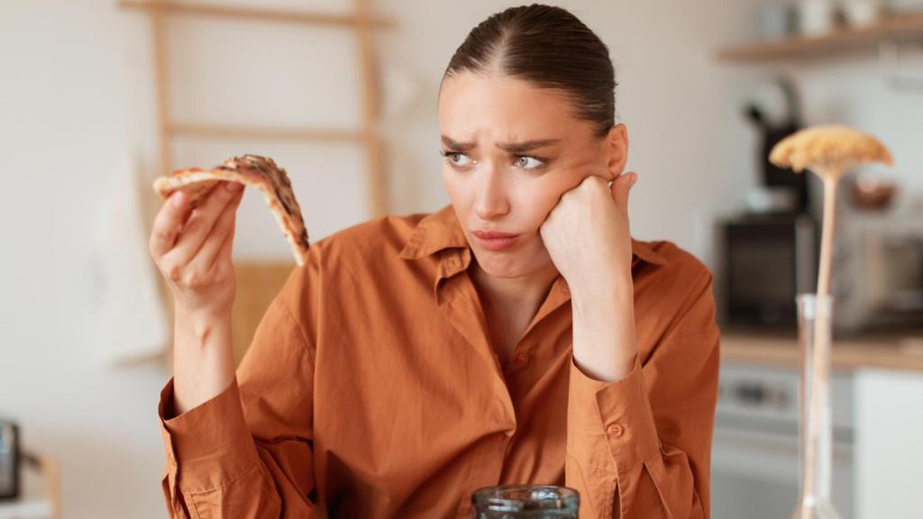 woman holding a piece of pizza