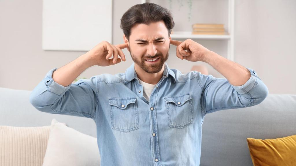 man plugging his ears