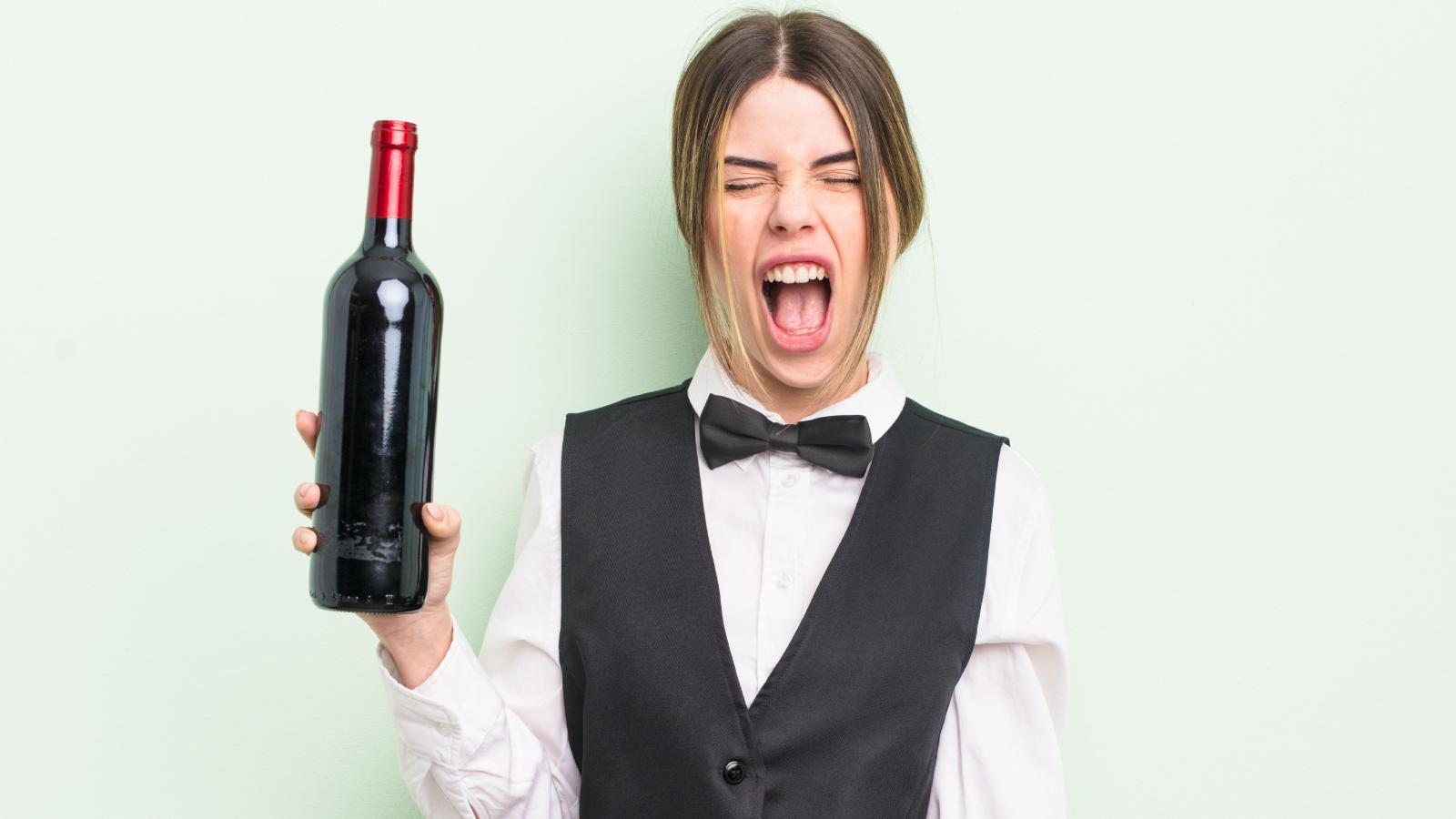A Waitress Accidentally Spills Red Wine On A Customer’s White Jacket And Is Terrified She Will Lose Her Job woman holding a bottle of wine