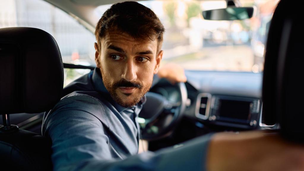 man backing up a car
