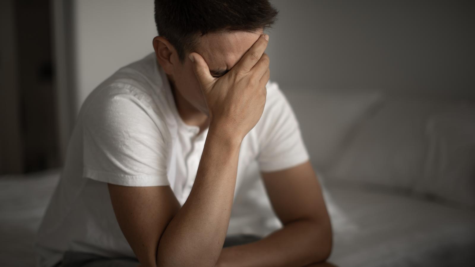 man crying on bed