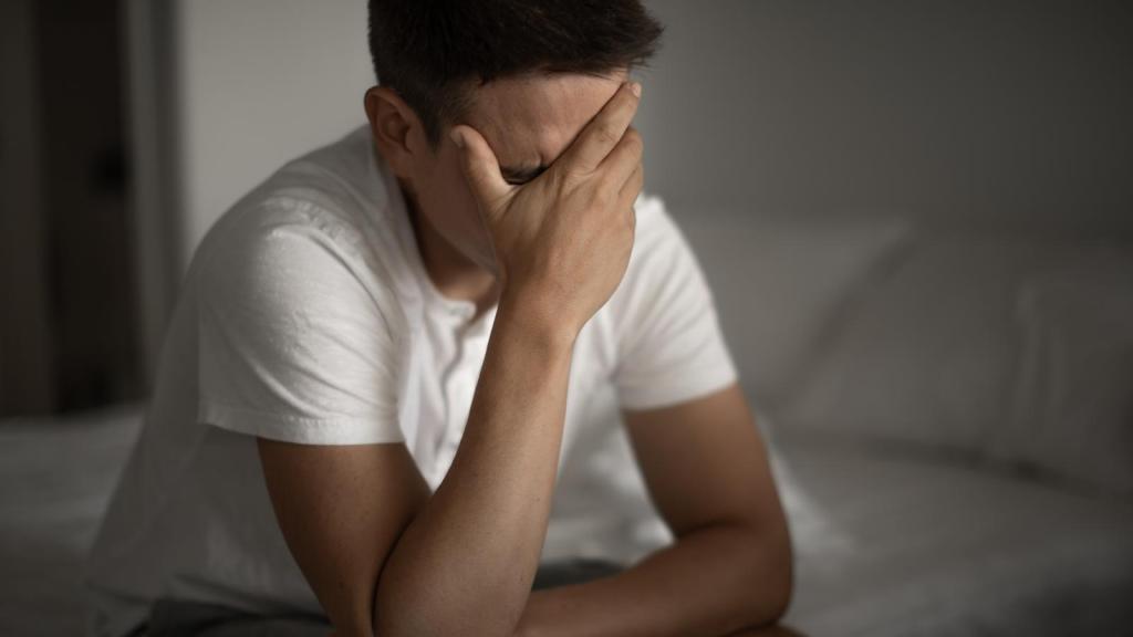 man crying on bed