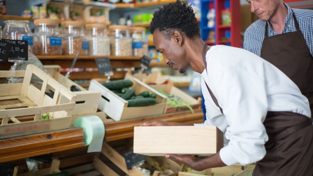 a grocery store employee restocking produce