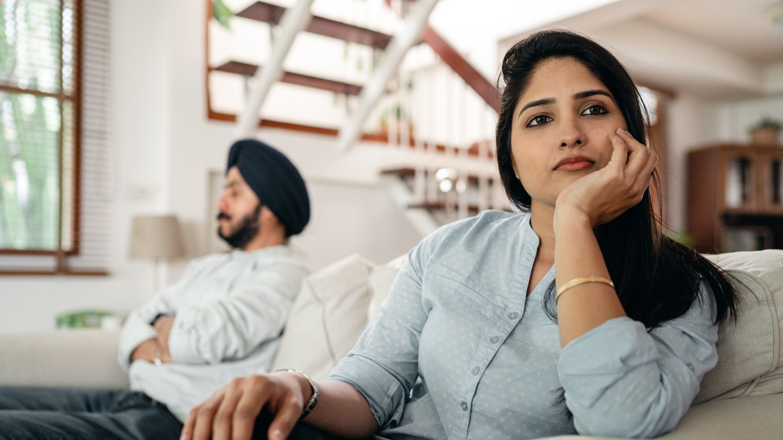Relationship Tension Grows After One Partner Uses Shared Savings Differently Than Planned a woman thinking and looking away from a man