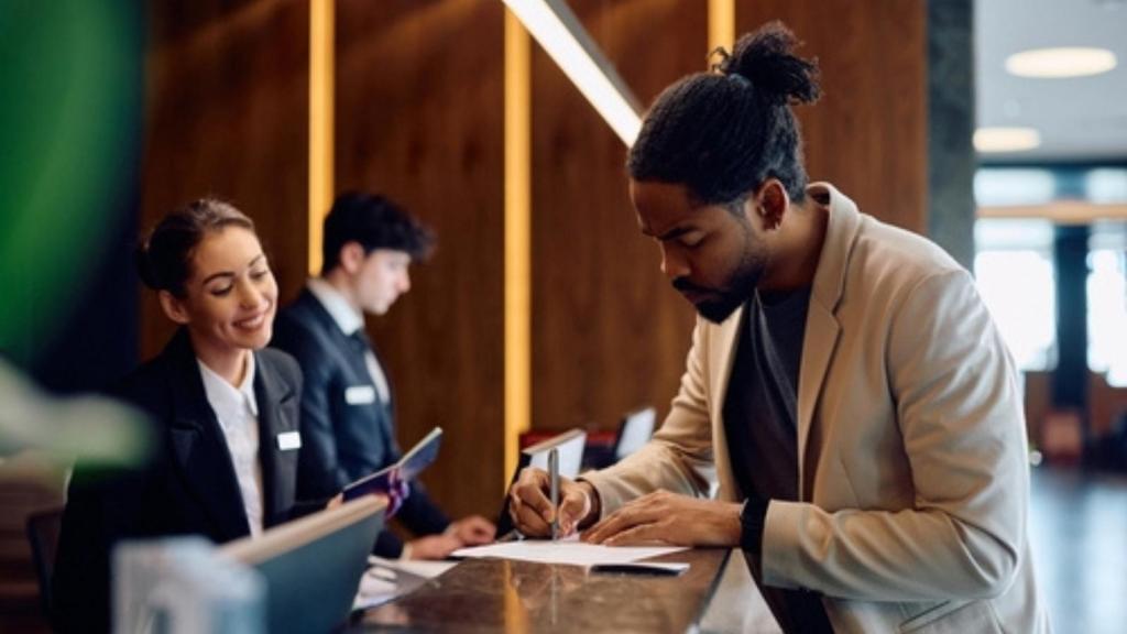 Hotel guest signing paperwork
