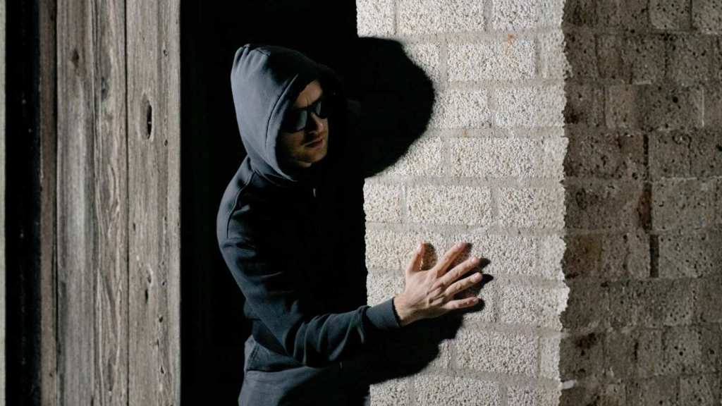 sketchy man in dark hoodie and sunglasses