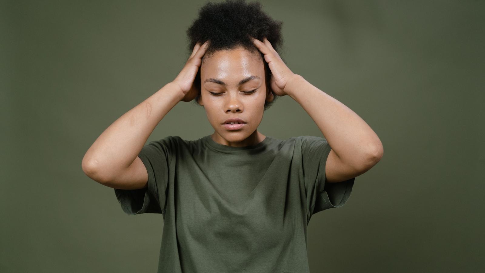 stressed young woman against green background
