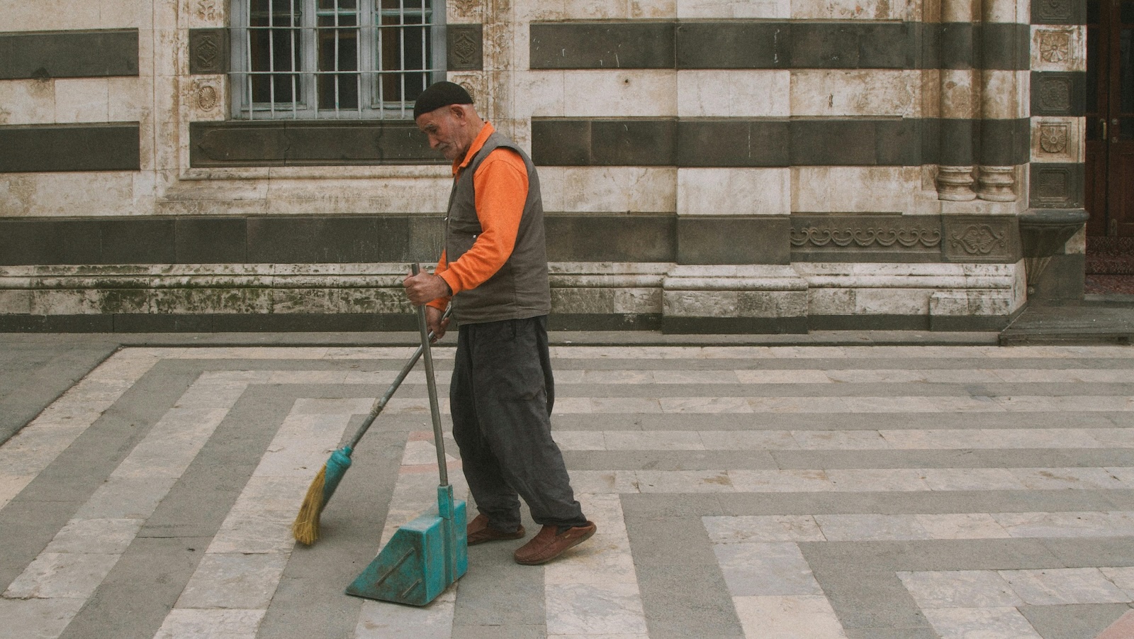 man sweeping outside