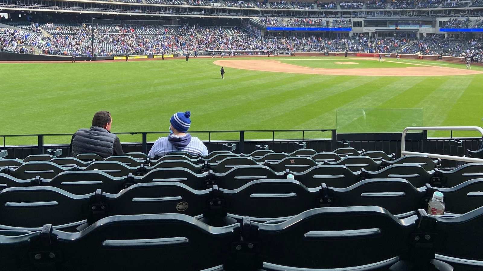 two men sitting at a baseball game