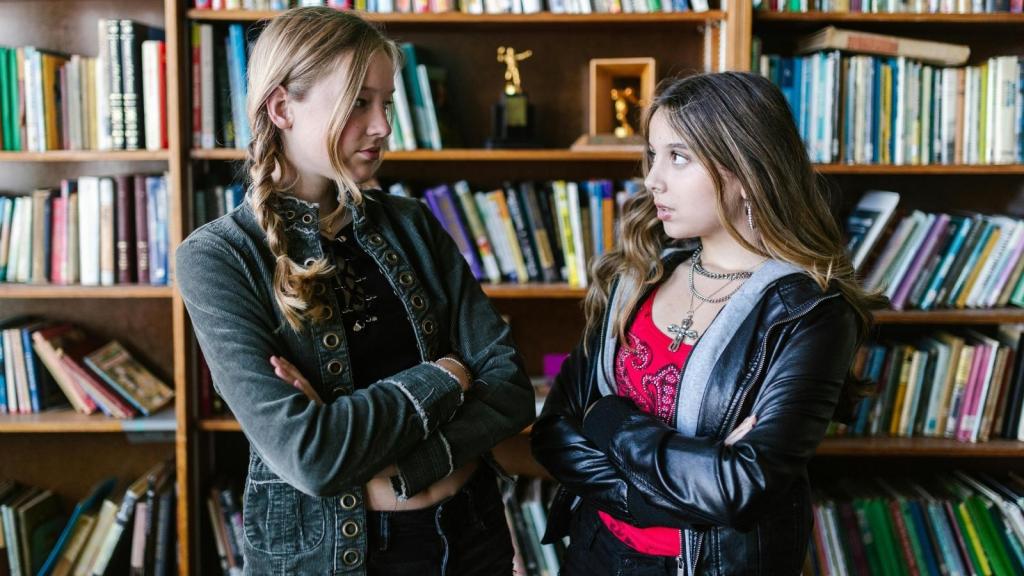 two pre teen girls arguing in a library