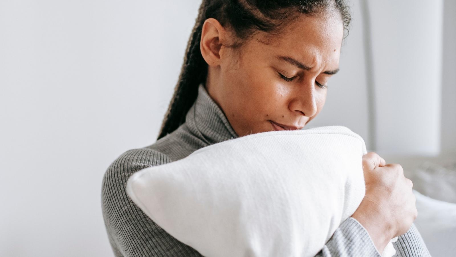 Woman Warned Her Younger Sibling That A Man She Had Known For One Week Was Already Asking To Move In, So Her Sister Called Her Judgmental And Accused Her Of Ruining Her Happiness upset woman hugging her pillow