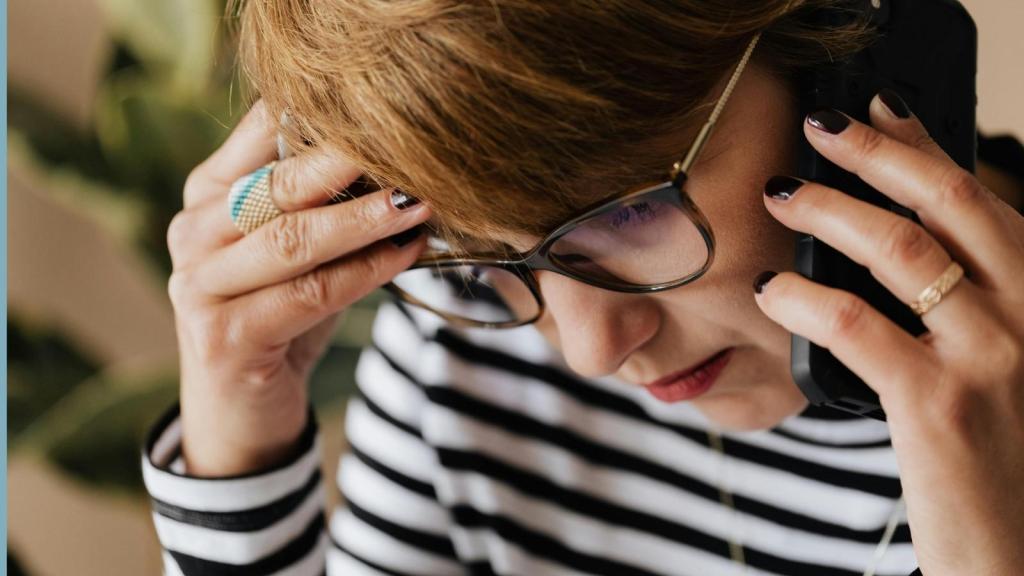 upset woman on the phone in striped shirt