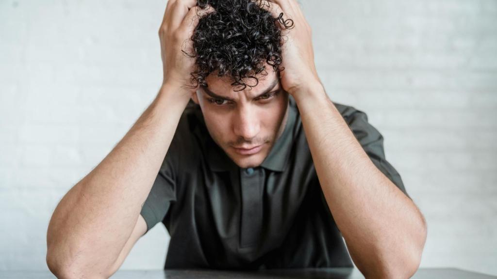 upset young man putting hands on head