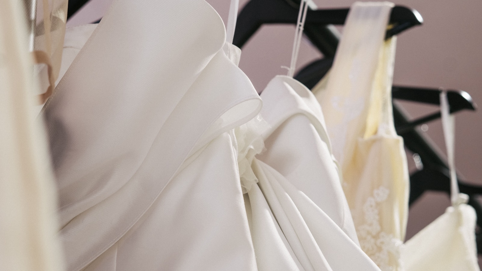 Bride Upset After Friend Questions Her $20,000 Wedding Dress Budget wedding dresses hanging up in a store