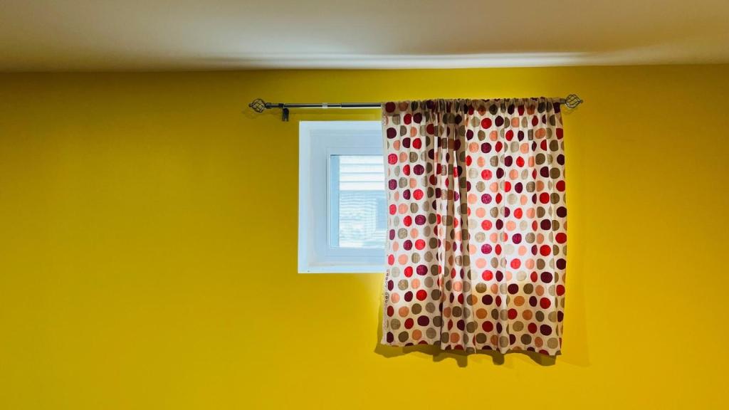 window with a curtain on a yellow wall