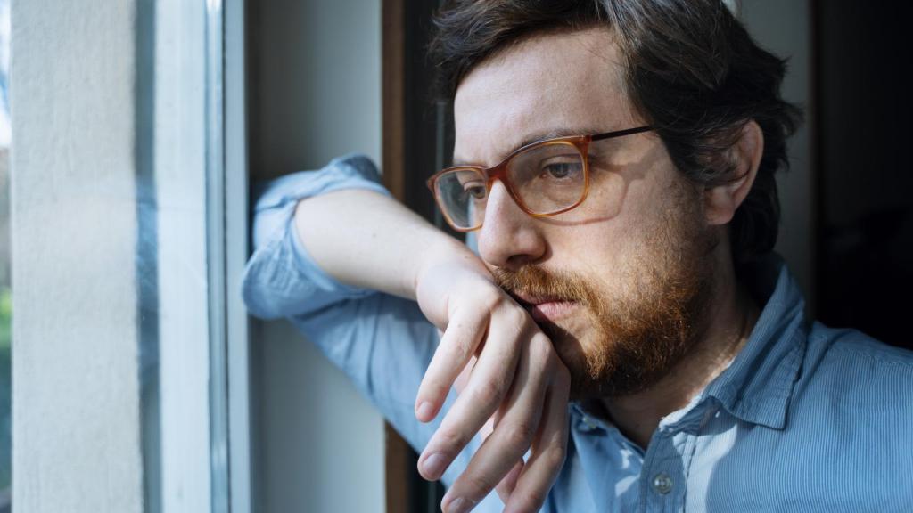 man looking out a window