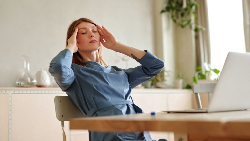 woman feeling stressed in front of her laptop