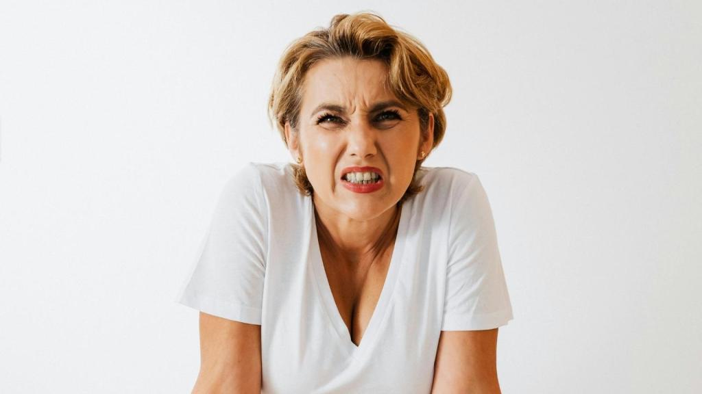 woman in white shirt making a disgusted face