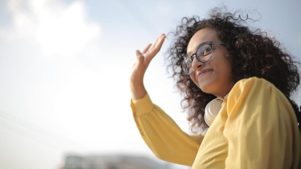 woman in yellow shirt waving goodbye
