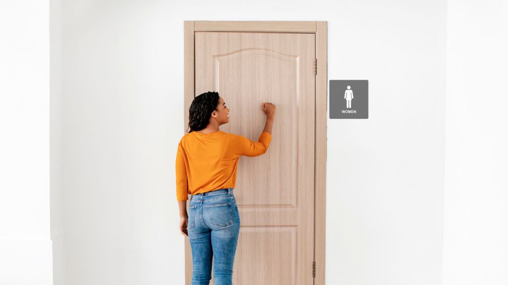 woman knocking on the restroom's door