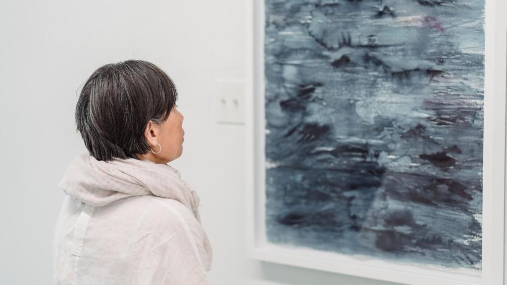 woman looking at a piece of art in art gallery