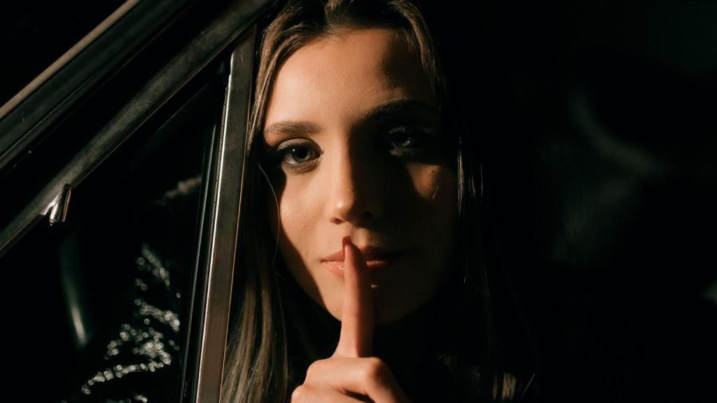 woman putting finger up to mouth telling a secret
