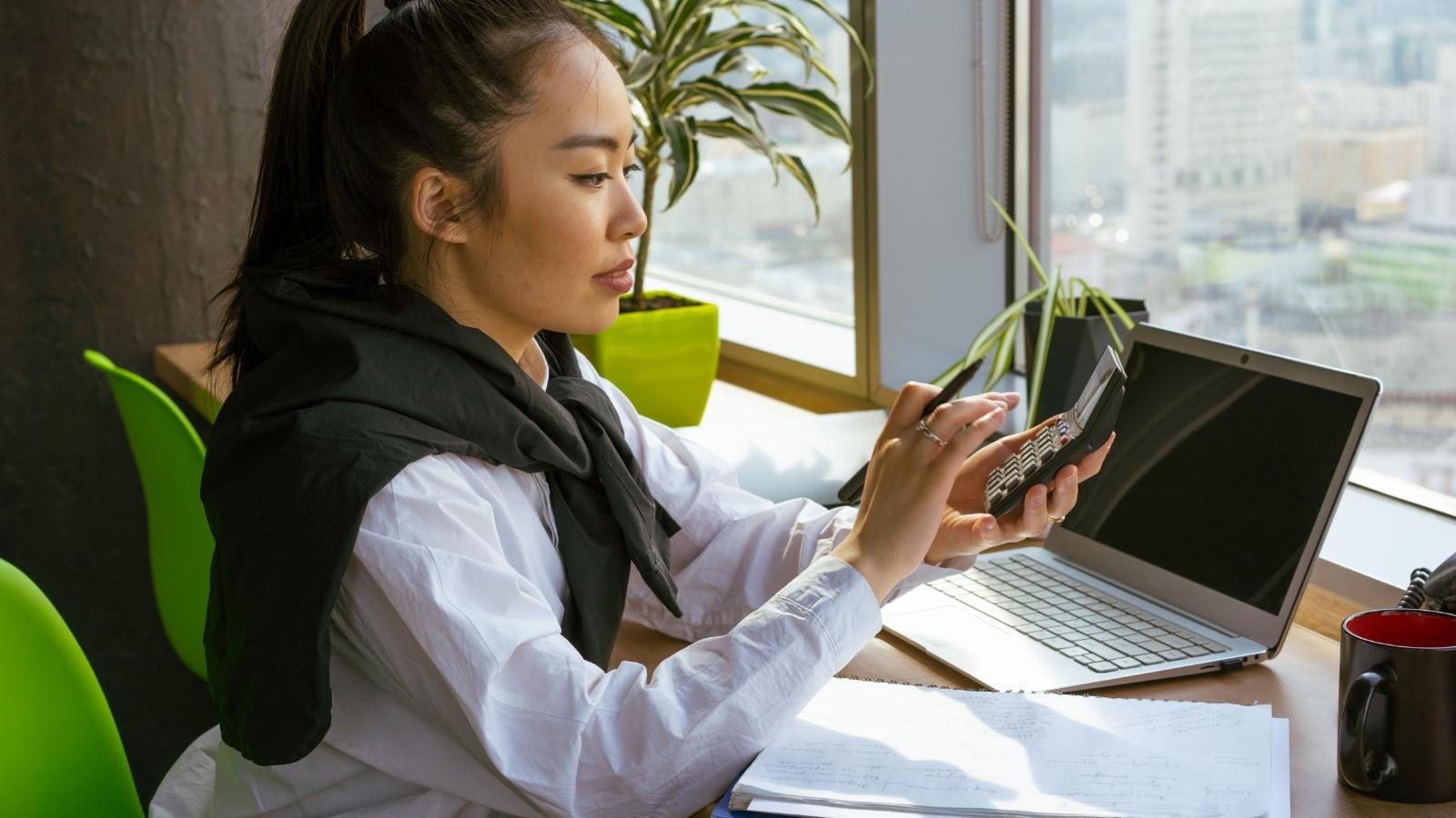 Her Boss Dumped Management Tasks and Customer Complaints on Her — So She Stopped Solving Problems That Were Never Her Job woman sitting at her desk with a calculator