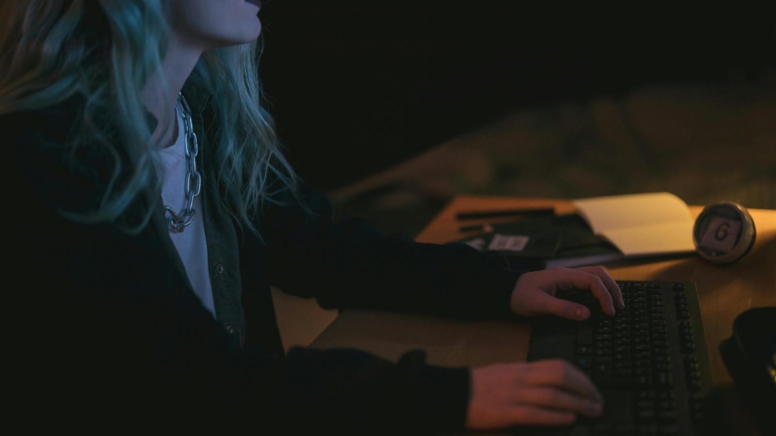 woman sitting in front of a computer late at night