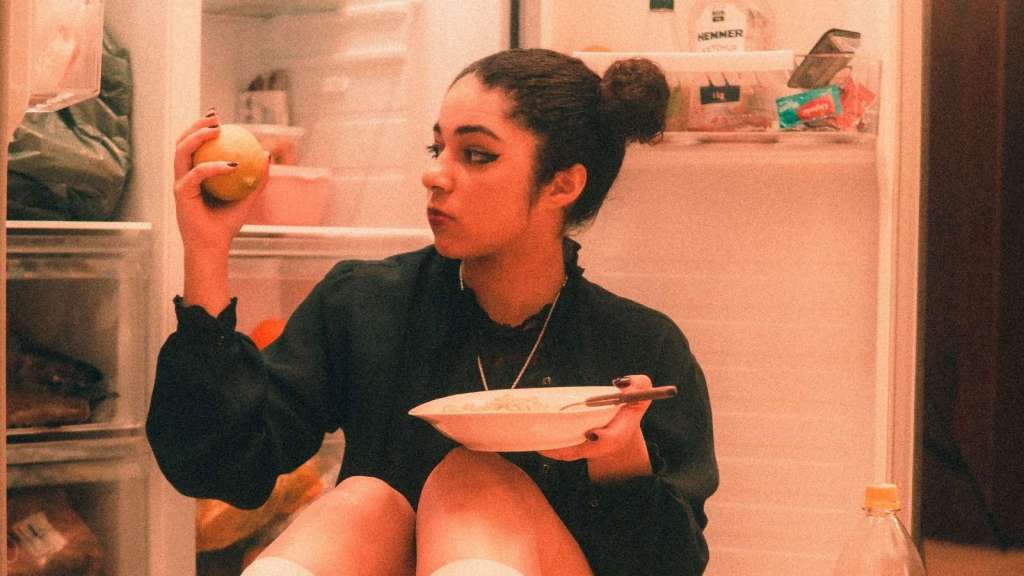 woman stealing food out of the fridge