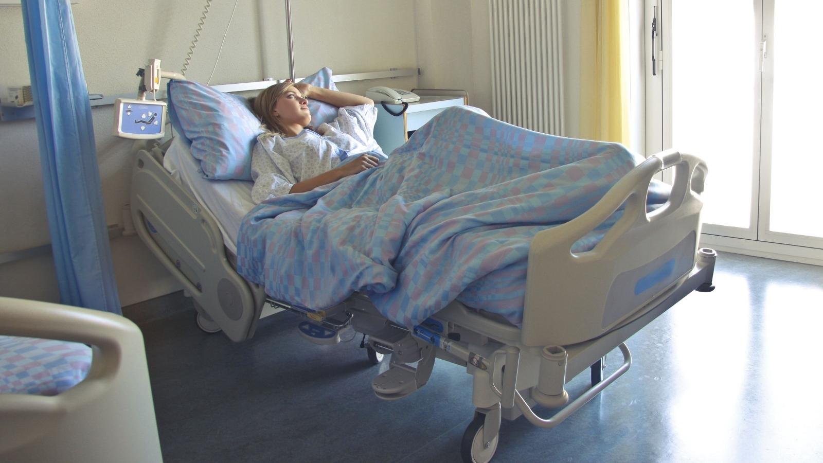 young woman sitting in hospital bed