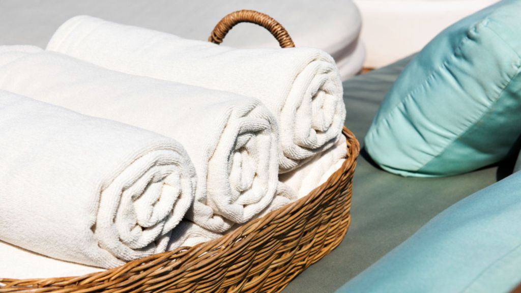 Clean white towels rolled and neatly placed in a basket