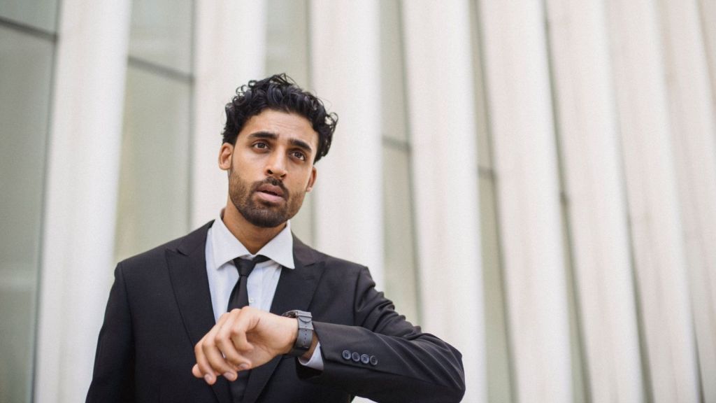 A man in a suit looking at his watch