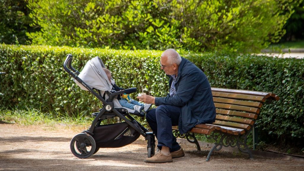 A grandpa with a baby in a stroller